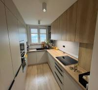 Kitchen in a 4-room apartment with a kitchen unit, appliances, and flooring with a wooden decor.