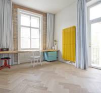 A room in a 4-room apartment with a wooden decor floor and a yellow radiator.
