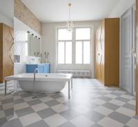 A bathroom with a freestanding bathtub, a blue cabinet, and a tiled floor in a 4-room apartment.