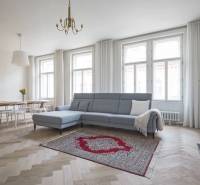 Spacious living room with a gray sofa and wood-patterned flooring in a 4-room apartment.