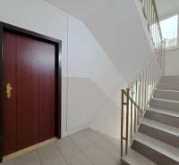Staircase and entrance door to a 4-room apartment with a window on the staircase.