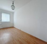 A room in a 4-room apartment with a chandelier and a floor with a wood decor.