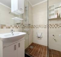 Bathroom with a shower and a sink in a 4-room apartment, floor with wood decor.