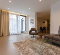 Living room in a two-room apartment with a comfortable sofa, an armchair, and a glass table.
