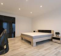 2-room apartment with wood-patterned flooring, a bed, a wardrobe, and an office chair.