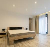 Bedroom in a 2-room apartment with a bed, nightstand, and floor with a wooden decor.