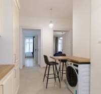 Hallway in a 3-room apartment with a washing machine, chairs, and a kitchen unit.