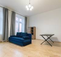 Living room with a blue sofa and a wooden decor floor in a 3-room apartment.