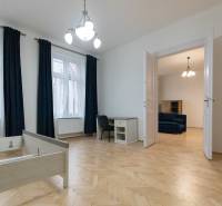 Interior of a 3-room apartment with wood-decor flooring, furniture, and a chandelier.