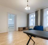 Living room in a 3-room apartment with a wooden decor floor and a blue sofa.