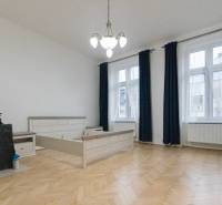 A room with light furniture, a wooden decor floor, and large windows in a 3-room apartment.