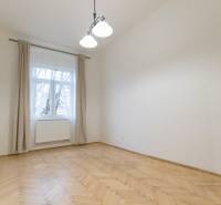 A room in a 3-room apartment with a wood-patterned floor and a large window.