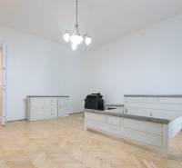 A bedroom with a bed, furniture, and flooring with a wooden decor in a 3-room apartment.