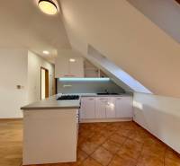 A kitchen in a 2-room apartment with a kitchen unit and a ceramic tile floor.