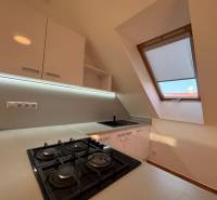 Kitchen in a 2-room apartment, built-in stove, sink, skylight, white cabinets.