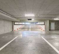 Parking spaces in garages with a ramp and white markings.