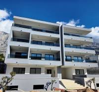 A recreational apartment in Makarska, a building with four floors and balconies, mountain backdrop.