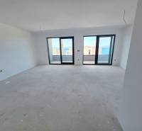Interior of a holiday apartment with a view through large windows of the sea.