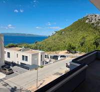 View from a holiday apartment in Makarska of the sea and green hills.