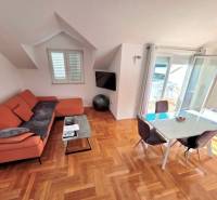 The recreational apartment offers a sofa, a dining table, and a floor with a wooden decor.