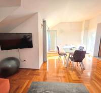 Interior of a holiday apartment with a wooden decor floor and a dining table.