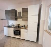 A kitchen with combined cabinets and built-in appliances in a Holiday Apartment.