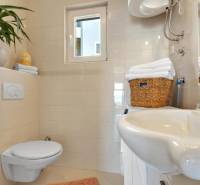 A bathroom in a 3-room apartment with a toilet, sink, and tasteful accessories.