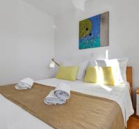 A bedroom in a 3-room apartment with simple furniture, white walls, and yellow decorations.