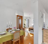 Dining room in a 3-room apartment with a wooden decor floor, set table, candles.