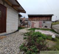A family house in Jasenica with a yard, a gravel path, and a wooden garage.
