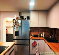 A kitchen in a family house with a stainless steel refrigerator and wooden countertops.