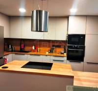 A kitchen in a family house with a wooden decor floor and modern equipment.