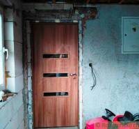 The interior of a family house with doors featuring a wood decor and an unfinished wall.