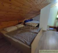 Attic room with wooden paneling and wood-decor flooring in a family house.