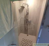 Shower corner with tiles and a towel in a family house.
