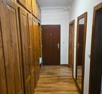 A hallway in a 3-room apartment with a wooden decor floor and built-in wardrobes.