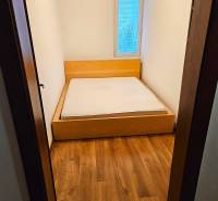 A bedroom in a 3-room apartment with a bed and a wooden decor floor.