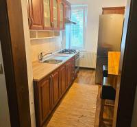 A kitchen in a 3-room apartment with a wooden decor and a light carpet.