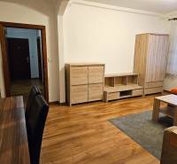 Living room in a three-room apartment with a wooden decor floor and wooden furniture.