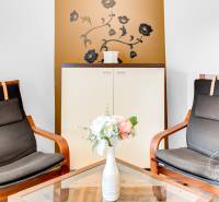 Two armchairs in a 2-room apartment with floral decorations and a wooden-patterned floor.