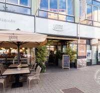 The exterior of Yeme in Bratislava on Medená, with outdoor seating and an ATM of Slovenská sporiteľňa.
