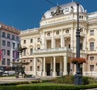 The historical building of the Slovak National Theatre in Bratislava with a fountain and lamps.
