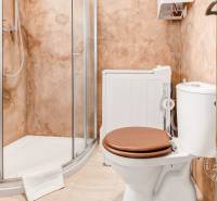 A bathroom with a shower and a washing machine in a 2-room apartment.