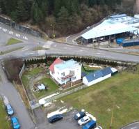 A family house on SNP Street in Považská Bystrica, surrounded by green areas and an intersection.