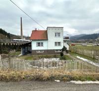 A family house on SNP Street in Považská Bystrica, with a garden and a fence in front of it.