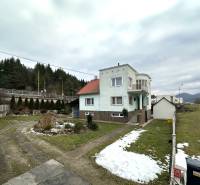 A family house on SNP Street in Považská Bystrica surrounded by a snowy garden and a driveway.