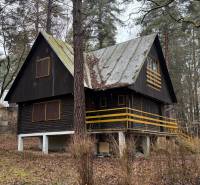 A cabin in the woods near Kováčová with a metal roof and wooden details.