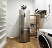A refrigerator and a washing machine in a 2-room apartment on Vajnorská Street, complemented by shelves and plants.