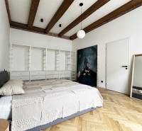 Bedroom in a 2-room apartment with wooden beams and a mirror on Vajnorská Street.
