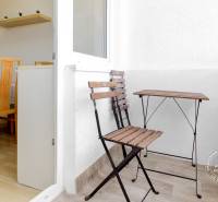 A balcony in a 3-room apartment with wooden furniture and a dining area.